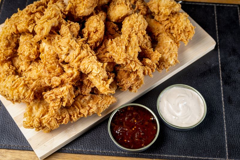 Golden chicken strips with three dipping sauces
